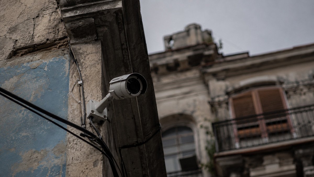 Cámara de vigilancia en la fachada desgastada de un edificio colonial Cámara de vigilancia en la fachada desgastada de un edificio colonial