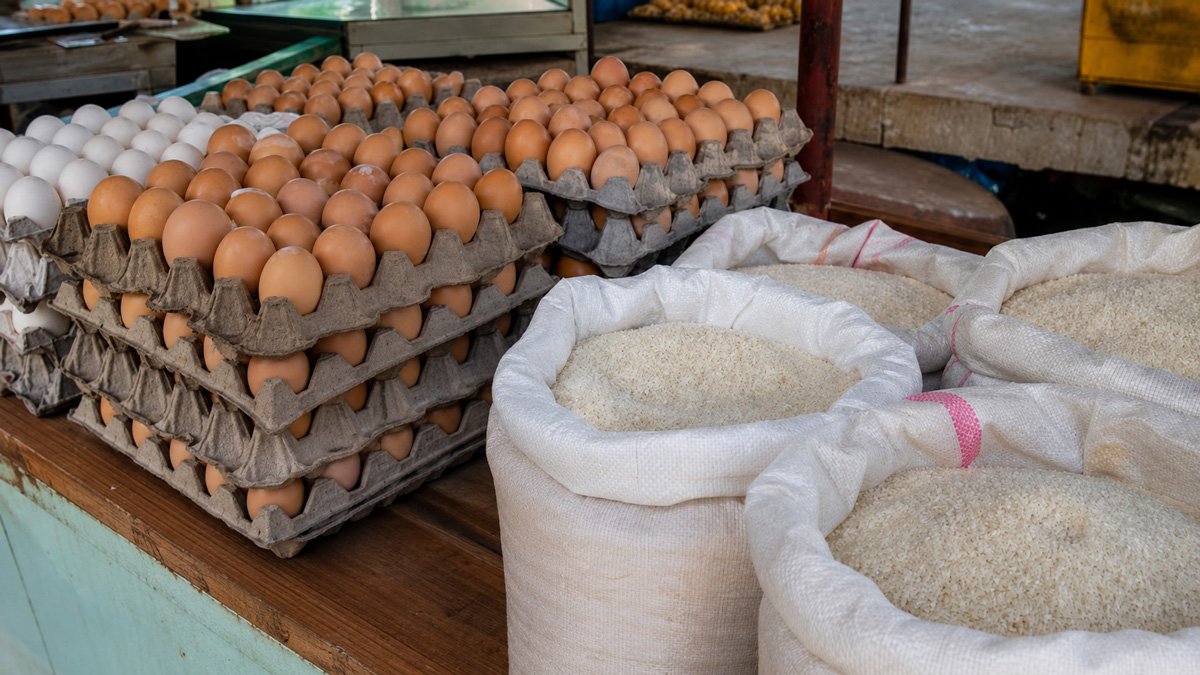 Cartones de huevos y sacos de arroz junto a pesos cubanos en un mercado agropecuario de Cuba, reflejo de la subida de precios de julio de 2026