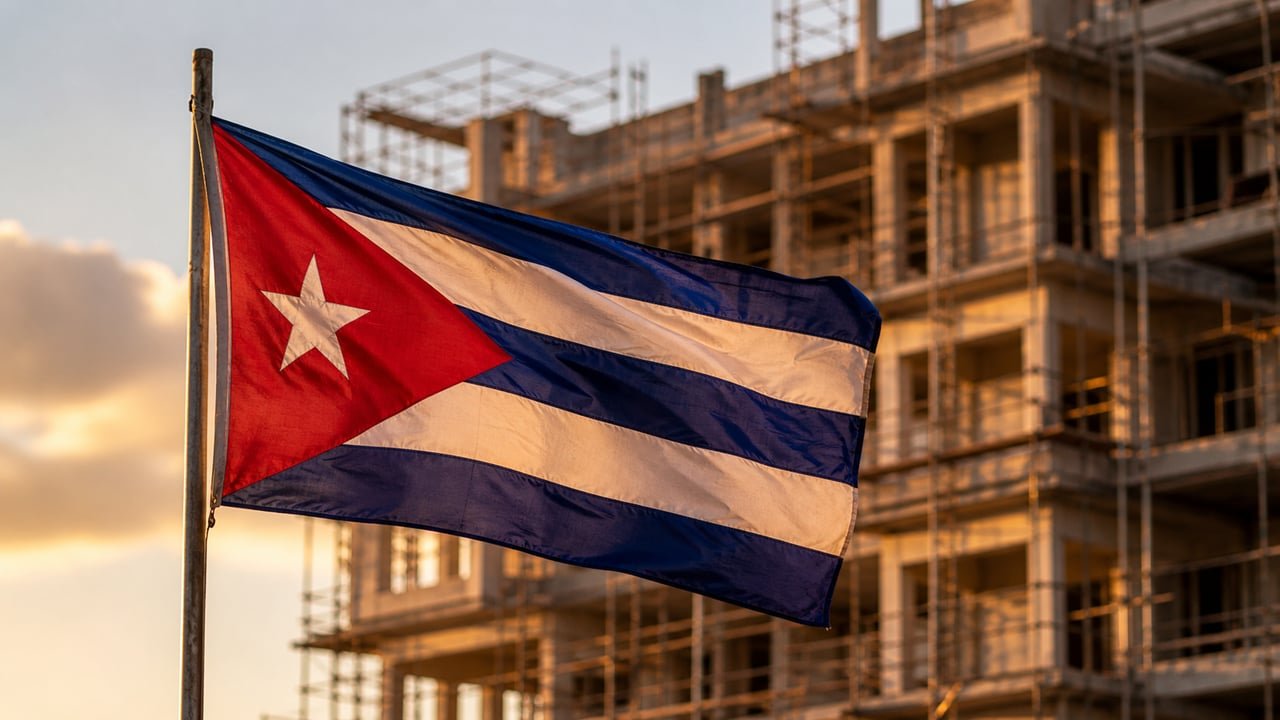 Bandera cubana ondeando frente a un hotel en construcción, símbolo del poder económico de GAESA en Cuba
